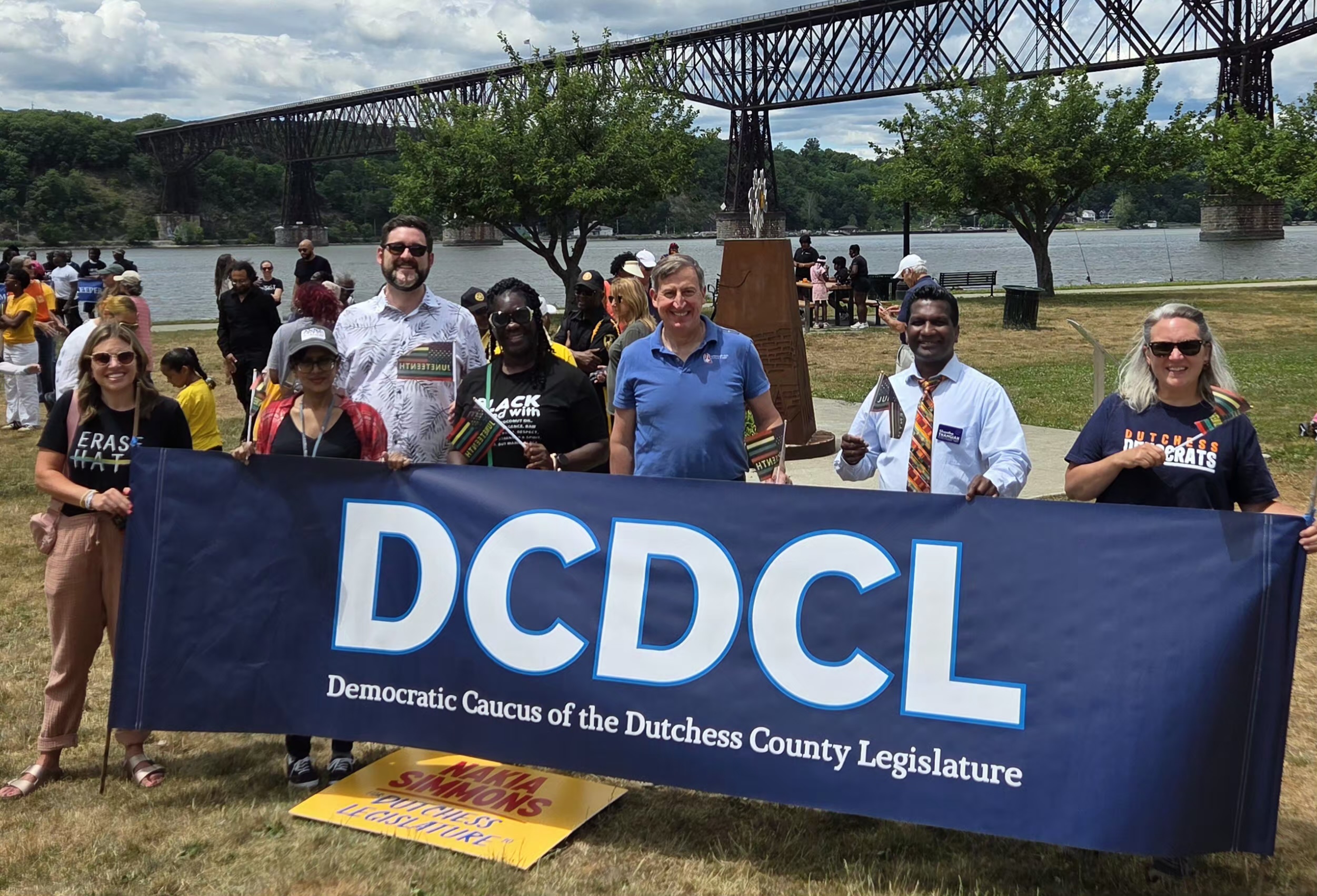 August and supporters holding the DCDCL banner at the Poughkeepsie waterfront